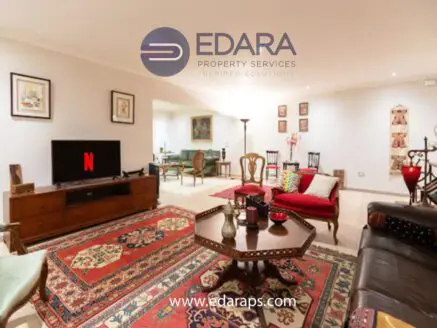 Interior view of a living room featuring a television, seating, and decorative elements.