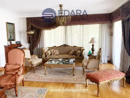 Living room featuring ornate furniture, a chandelier, and large windows with drapes.