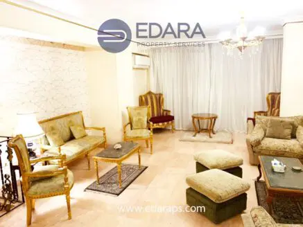 Spacious living room featuring ornate chairs, a sofa, and a coffee table with a decorative design.