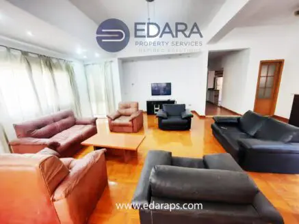 Spacious living room featuring leather sofas, a coffee table, and a television setup.