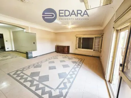 Interior view of a residential space featuring decorative tile flooring and a wooden cabinet.