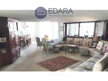 Spacious living room featuring sofas, a coffee table, and decorative items in a neutral color scheme.