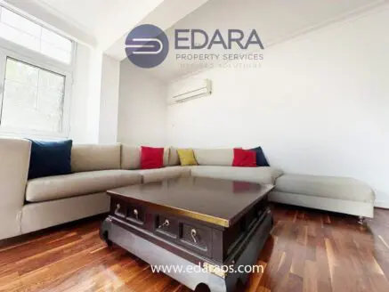 Modern living room featuring a sectional sofa and a wooden coffee table on hardwood flooring.