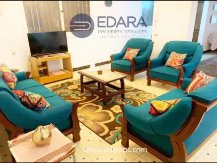 Living room featuring a teal upholstered furniture set with decorative pillows and a wooden coffee table.