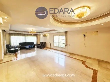 Bright living room featuring marble flooring, large windows, and modern furniture including black sofas and a chandelier.