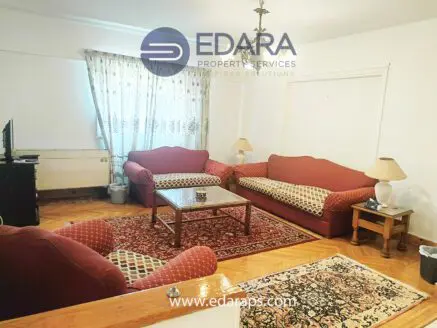 Living room featuring red upholstered sofas, a coffee table, and a decorative rug on the floor.