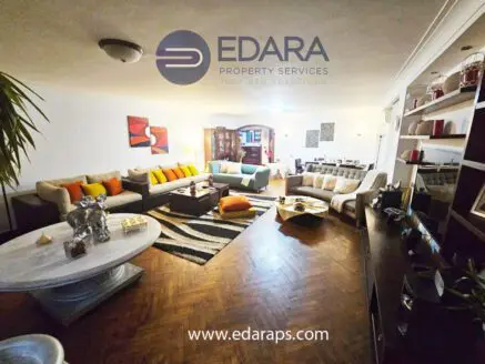 Spacious living room featuring modern furniture, decorative cushions, and a coffee table.