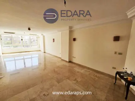 Bright, spacious room with marble flooring and large windows allowing natural light.