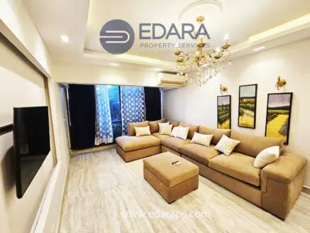 Spacious living room featuring a large beige sectional sofa and framed artwork on the walls.