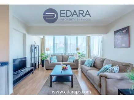 Modern living room featuring a beige sofa set, coffee table, and decorative cushions.