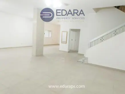 Interior view of a spacious room with tiled flooring and a staircase in a residential property.