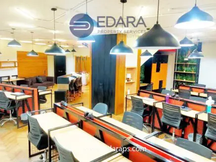 Interior view of a modern co-working space featuring desks, chairs, and pendant lighting.