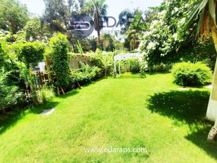 Lush green garden with flowering plants and outdoor sitting area – Edara Property Services, Garden in Maadi, Cairo.