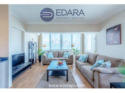Spacious living room with large windows, cozy sofas, and modern decor - Edara Property Services.