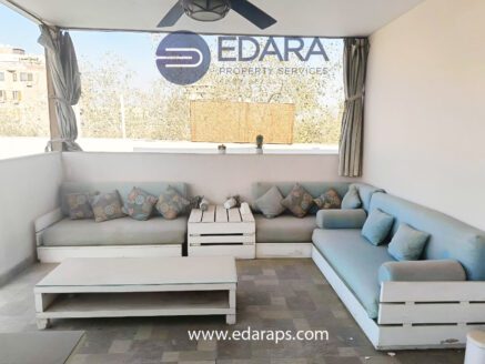 Covered outdoor seating area with white sofas and coffee table - Edara Property Services