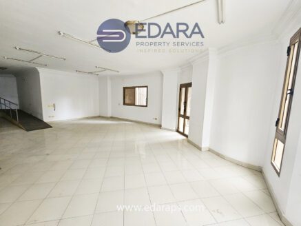 Empty commercial space featuring white walls and tiled flooring with large windows.