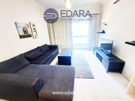 Living room with dark sofa and TV – Edara Property Services